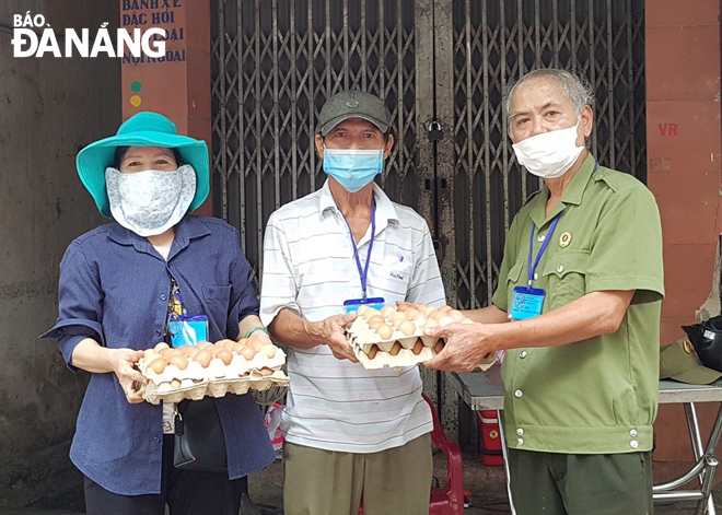 Ông Nguyễn Hiền Minh tặng quà cho những hộ dân có hoàn cảnh khó khăn trong khu dân cư . Ảnh: V. T