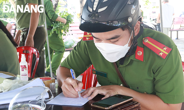   Lieutenant Vo Thanh Dat from Hai Chau 1 Ward Police in Hai Chau District makes  statistics on orders from the authorities of the residential areas through Zalo messages. Photo: DAC MANH