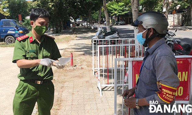  Police officers in charge of a sales point at 193 Ha Huy Tap, Hoa Khe Ward, Thanh Khe District receive orders from residential groups. Photo: M. QUE