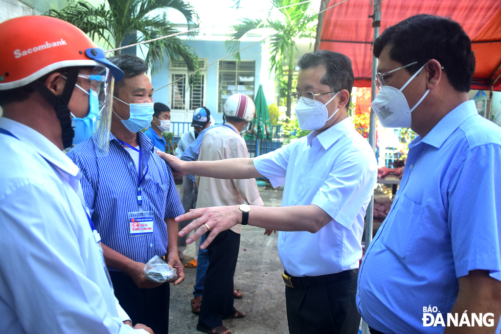 Da Nang Party Committee Secretary Nguyen Van Quang (second, right) highly praises residential groups' staffers for actively doing shopping for locals. Photo: TRONG HUY