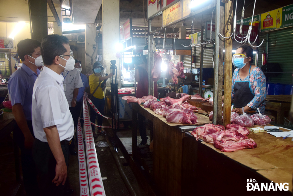 .  Da Nang Party Committee Secretary Nguyen Van Quang  (right) visits Hoa My wet market to check the food quality here. Photo: TRONG HUY