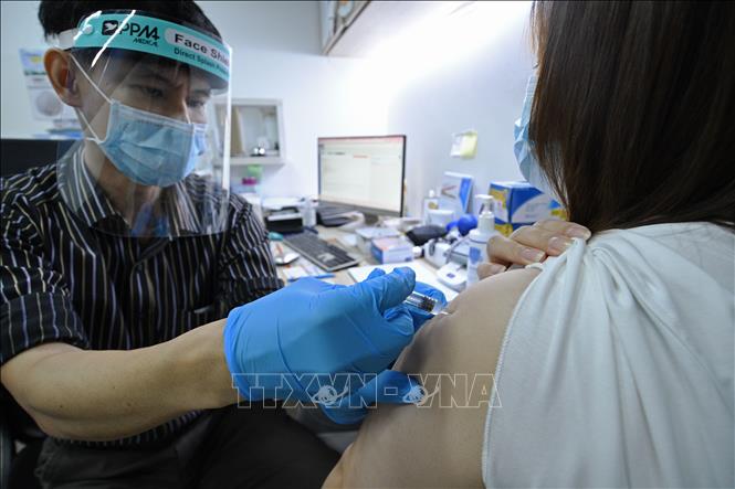 Nhân viên y tế tiêm vaccine phòng Covid-19 cho người dân tại Singapore. Ảnh: THX/TTXVN