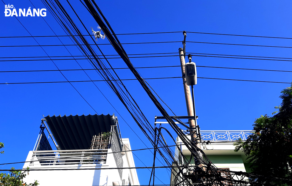 A flycam is on mission to fullfil surveillance tasks above a narrow alley. Photo: TRONG HUY