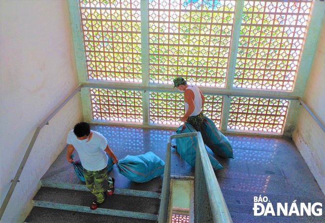 Officers and soldiers from the Da Nang Military High Command assist the displaced students in transporting their personal belongings down to the ground for the movement to the Ngu Hanh Son District-based dormitory.