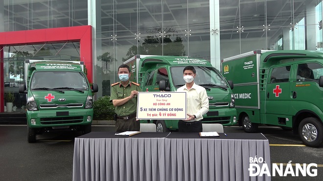 A representative of the Police Hospital 199 (left) receives a symbolic board of donations from a respresentative from THACO. Photo: XUAN SON