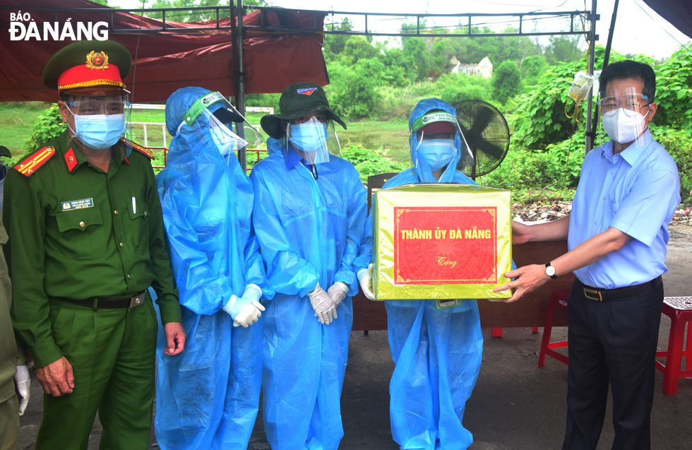 Da Nang Party Committee Secretary Nguyen Van Quang (right) presents gifts to the functional forces on duty at the C22 checkpoint on a section of Nam Ky Khoi Nghia Street, August 31, 2021. Photo: TRONG HUY