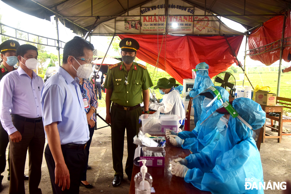 Da Nang Party Committee Secretary Nguyen Van Quang (left) extends his words of great encouragement to the medical staff on duty at the C22 checkpoint on Nam Ky Khoi Nghia Street, August 31, 2021. Photo: TRONG HUY