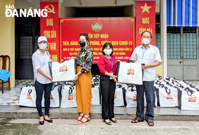 Đại diện Công ty CP Đô thị FPT Đà Nẵng (thứ 2 bên trái) cùng ông Dương Đình Liễu (ngoài cùng bên phải) - Phó Chủ tịch Ủy ban MTTQ Việt Nam thành phố chuyển 500 suất quà đến Ủy ban MTTQ Việt Nam quận Cẩm Lệ.