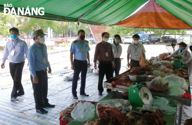 Ban Quản lý ATTP thành phố phối hợp với Sở Công Thương kiểm tra chất lượng thực phẩm tại chợ tạm trên địa bàn quận Liên Chiểu. Ảnh: PHAN CHUNG