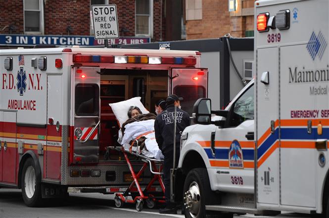 Nhân viên y tế chuyển bệnh nhân COVID-19 tới trung tâm y tế tại New York, Mỹ. Ảnh: AFP/ TTXVN