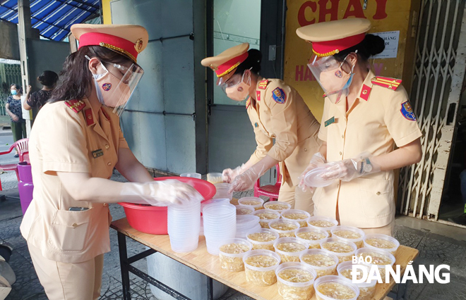 Sau giờ trực chốt, các nữ Cảnh sát giao thông Công an thành phố nấu cơm, súp để hỗ trợ người dân, cũng như các chốt phòng, chống dịch. Ảnh: NGỌC PHÚ
