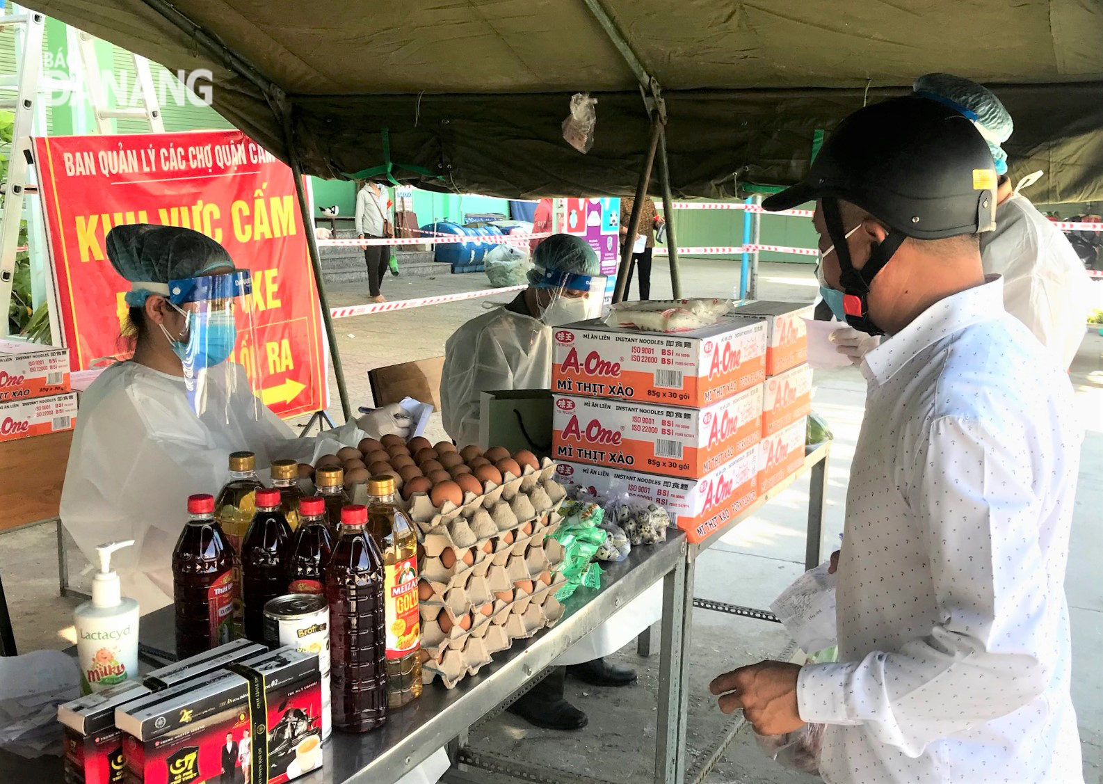 Members of the authorities of local residential groups do the purchase of goods for their locals at a mobile sales point deployed by the Da Nang Police in Hoa An Ward, Cam Le District. Photo: MAI QUE