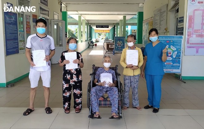 A representative of the Da Nang Lung Hospital (first, right) and the recovered patients pose for a photograph before they leave the hospital on Wednesday morning.