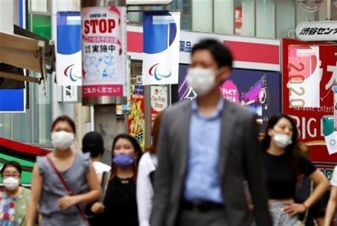 Người dân đeo khẩu trang phòng dịch Covid-19 khi di chuyển trên đường phố tại Tokyo, Nhật Bản, ngày 23-8-2021. Ảnh: Kyodo/ TTXVN