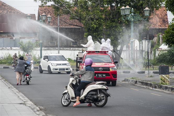 Phun thuốc khử trùng để ngăn chặn dịch Covid-19 tại Yogyakarta, Indonesia, ngày 8-8-2021. Ảnh: THX/ TTXVN