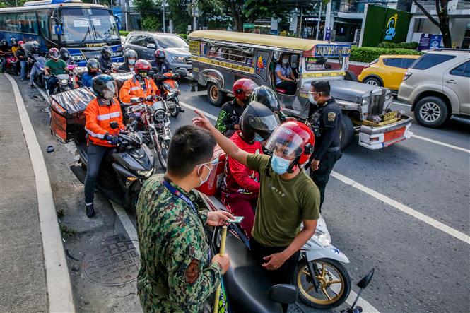 Cảnh sát kiểm tra các phương tiện để phòng dịch Covid-19 tại Quezon, Philippines, ngày 6-8-2021. Ảnh: THX/ TTXVN