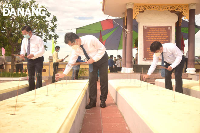 The City leaders burning incense at martyrs’ graves in the Phuoc Ninh Martyrs Cemetery. Photo: TRONG HUY