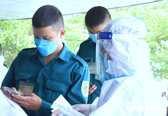 Medical staffer check vaccination information sheets at a centralized injection point set up within the Da Nang Oncology Hospital. Photo: NGOC PHU