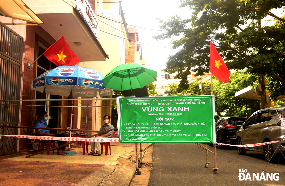 The national flag is seen hanging in the front of a COVID-19 checkpoint on Dang Tu Kinh Street, Thach Thang Ward, Hai Chau District. Photo: TRONG HUY