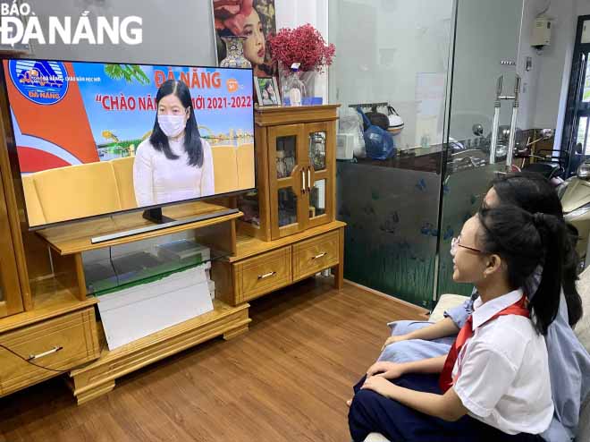  Pupils of the Tay Son Junior High School and their parents watch the online opening ceremony of the new school year  Photo: NGOC HA.