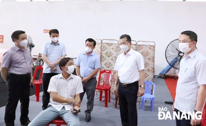 Bí thư Thành ủy Nguyễn Văn Quảng động viên thăm hỏi người dân được tiêm vắc-xin. Ảnh: NGỌC PHÚ