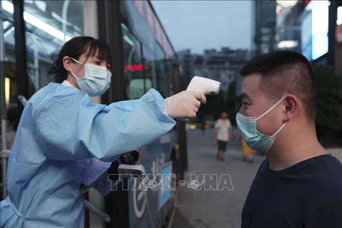 Người dân được kiểm tra thân nhiệt trước khi vào một điểm tiêm chủng ngừa COVID-19 ở Trùng Khánh, Trung Quốc ngày 20/8/2021. Ảnh minh họa: THX/TTXVN