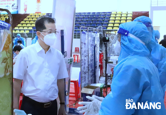 Municipal Party Committee Secretary Nguyen Van Quang (left) visiting the vaccination site at the Thanh Khe District Cultural Center to encourage the best possible performance from healthcare workers who are administering vaccines here. Photo: NGOC PHU