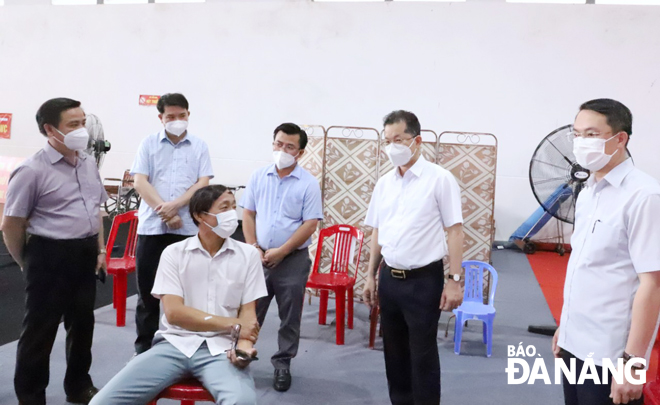 Secretary Quang (second, right) visits and encourages people who get vaccinated against COVID-19. Photo: NGOC PHU