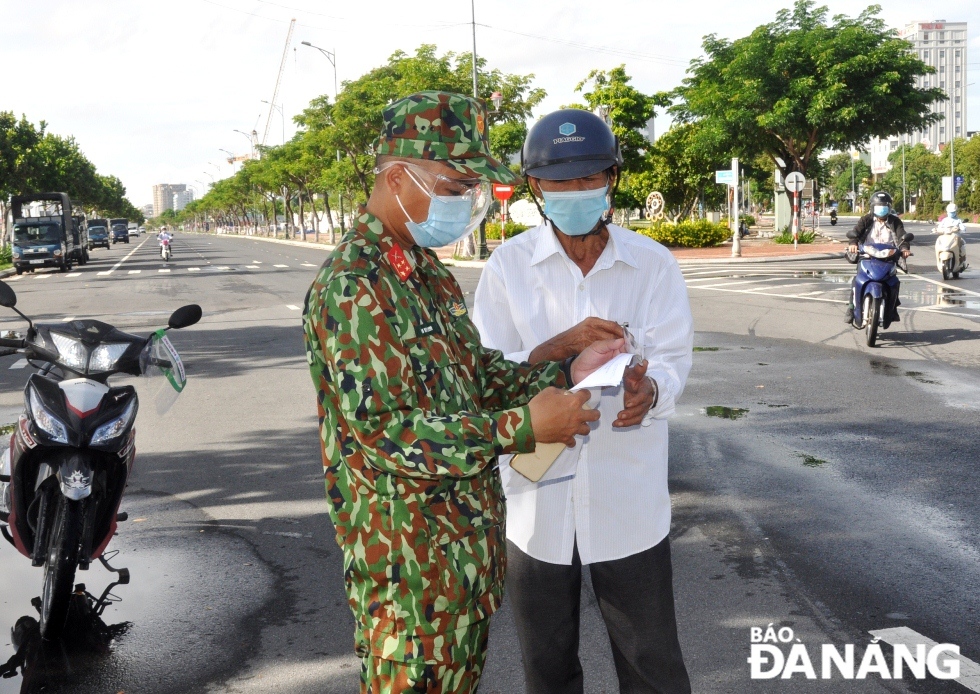 Lực lượng làm nhiệm vụ tại điểm chốt nằm trên tuyến đường 2 Tháng 9 (quận Hải Châu) kiểm tra, hướng dẫn trường hợp có giấy hẹn khám chữa bệnh của cơ sở y tế. Ảnh: LÊ HÙNG