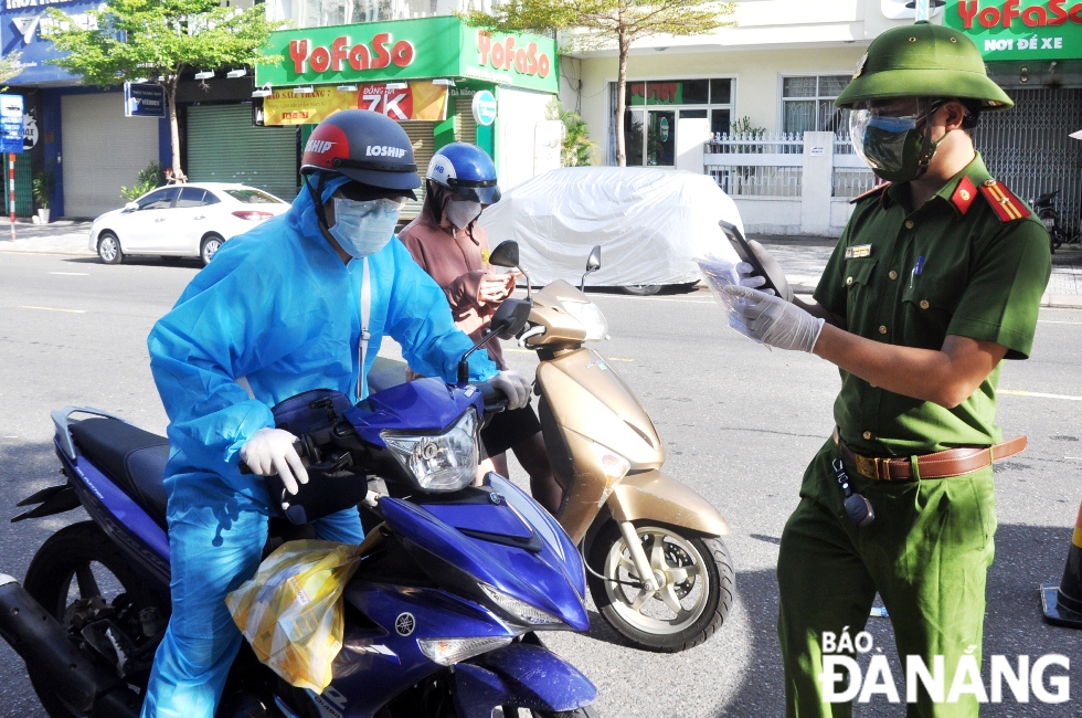 The taskforce at the checkpoint on Le Duan Street in Hai Chau District pulling over a shipper to check his travel permit