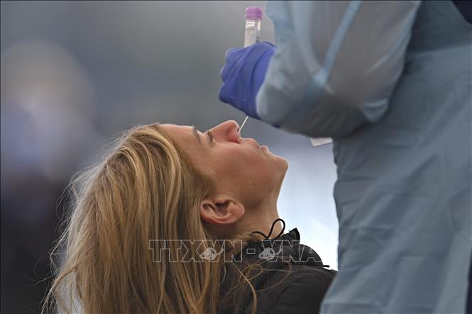 Nhân viên y tế lấy mẫu xét nghiệm COVID-19 cho người dân tại Sydney, Australia. Ảnh: AFP/TTXVN 