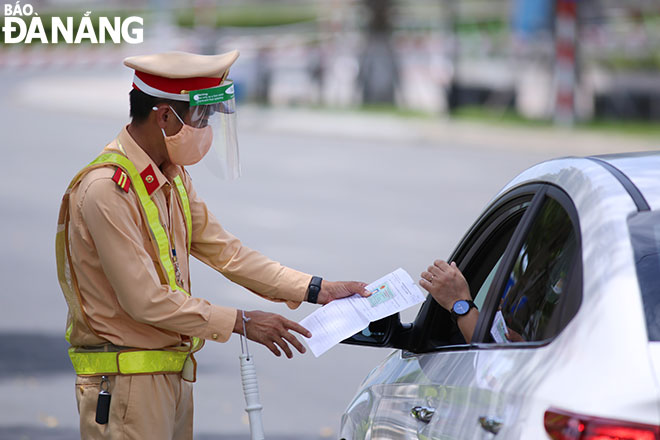 Lực lượng Cảnh sát giao thông, Công an thành phố kiểm tra giấy đi đường của người tham gia giao thông trên tuyến đường Bạch Đằng, quận Hải Châu trong những ngày Đà Nẵng thực hiện “ai ở đâu thì ở đó”. Ảnh: ĐỨC HOÀNG