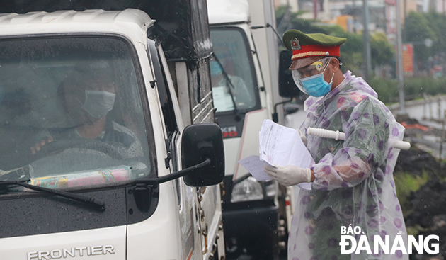 Police officers in Lien Chieu District check travel permit of road users on Ton Duc Thang Street. Photo: DAC MANH