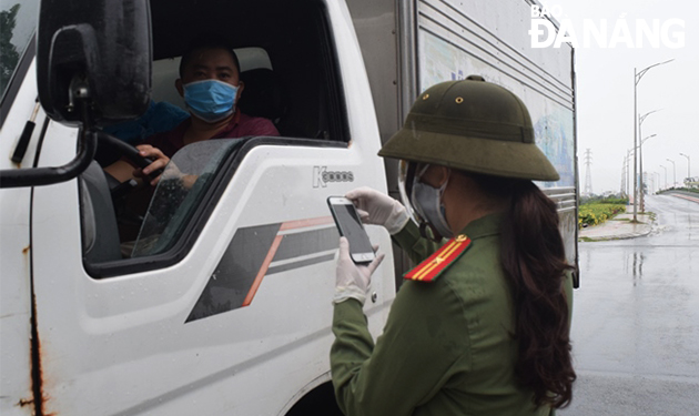 A female military officer performing her duty at the checkpoint on Nguyen Phuoc Lan Street in Hoa Xuan Ward, Cam Le District. Photo: HOANG HIEP