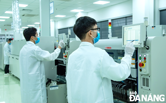 Businesses in the city are exerting greater efforts to maintain production with proper precautions in place. IN PHOTO: Engineers are operating the SMT high-tech electronics manufacturing and assembly factory (Trung Nam EMS) located in Da Nang Hi-Tech Park. Photo: PHAM DANG KHIEM