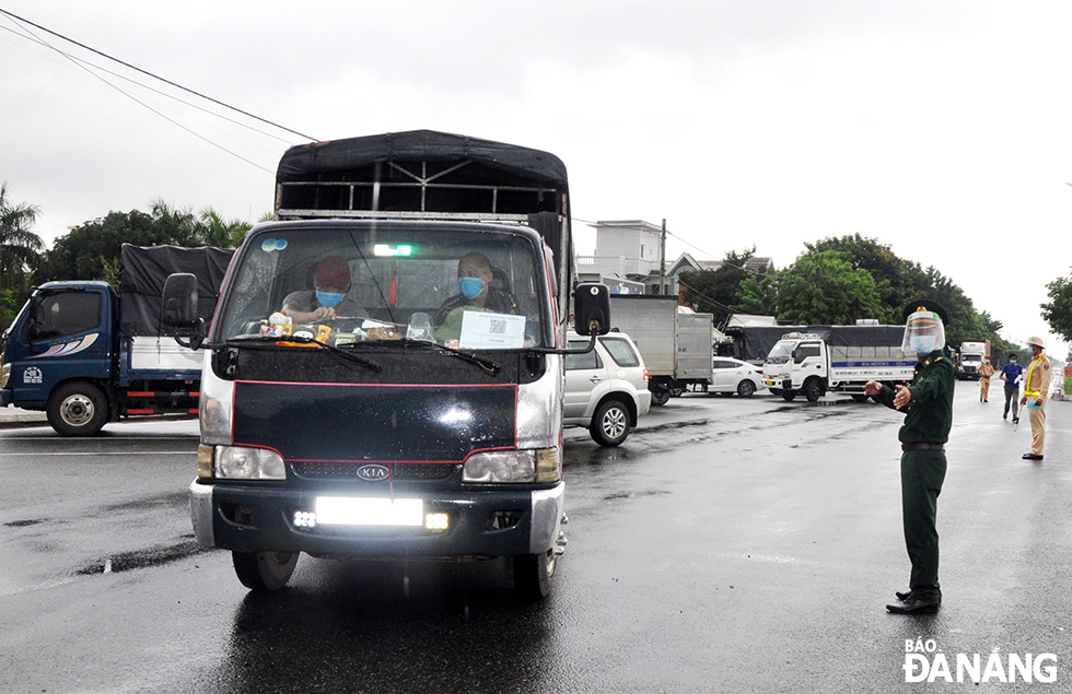  Traffic police on duty at a checkpoint on Tran Dai Nghia Street guides vehicles into the parking bay so that drivers have their swab samples taken for rapid antigen testing.