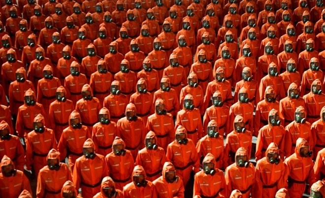 Các quân nhân trong bộ đồ phòng độc màu cam diễu hành trong lễ duyệt binh ở Bình Nhưỡng, nhân kỷ niệm 73 năm thành lập nước Cộng hòa Dân chủ Nhân dân Triều Tiên. (Nguồn: aljazeera.com)