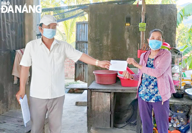 Cán bộ UBND xã Hòa Ninh trao tiền hỗ trợ cho người dân, bảo đảm quy định phòng, chống dịch bệnh. 							      Ảnh: N.Đ