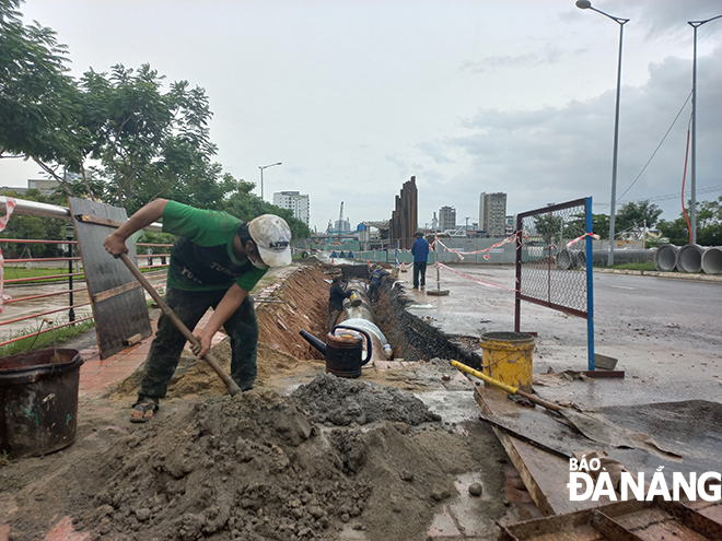 Tốp công nhân của kíp thợ cuối cùng tại công trình dự án Nút giao thông phía tây cầu Trần Thị Lý thi công đấu nối tuyến cống thoát nước để chống nhập úng vào công trình.  