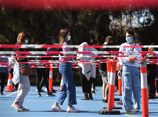 Người dân xếp hàng chờ tiêm vaccine ngừa COVID-19 tại một điểm tiêm chủng ở Melbourne, Australia. Ảnh: AFP/TTXVN