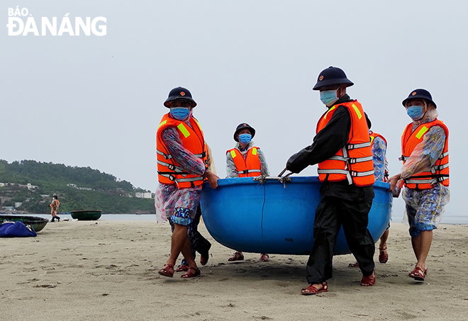 Officers and men of the Naval Zone 3 helping fishermen in Lien Chieu District bring their basket boats ashore.