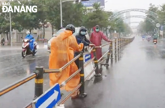 The task forces repair the traffic lane separator on Le Duan Street in Hai Chau District damaged by heavy rains and high winds.