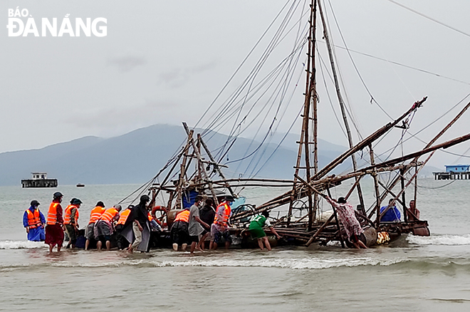 Officers and men of the Naval Zone 3 helping locals move their basket boat out of the water