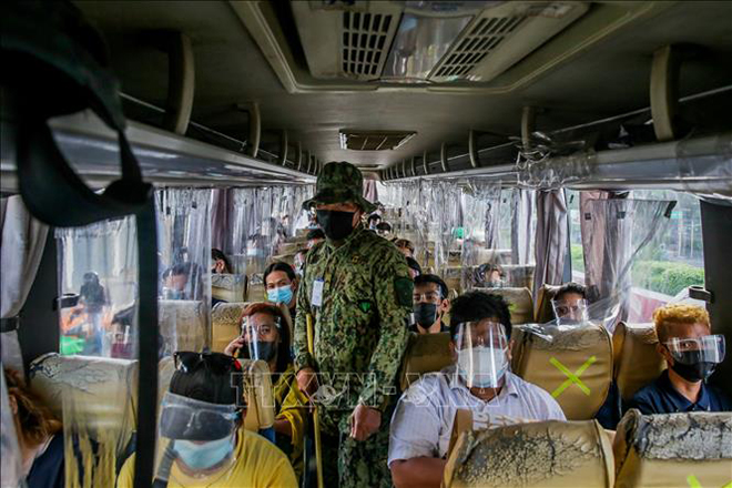 Cảnh sát kiểm tra nhắc nhở người dân thực hiện các biện pháp phòng dịch Covid-19 trên xe buýt ở Quezon, Philippines. Ảnh: THX/TTXVN