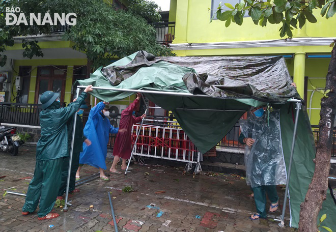 Lực lượng chức năng dựng lại trại che mưa để phục vụ kiểm soát người và phương tiện lưu thông ở chốt kiểm soát trên tuyến đường Trần Hưng Đạo. Ảnh: HOÀNG HIỆP