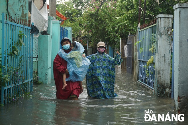 People living in Khe Can area, Thanh Khe Tay Ward, Thanh Khe District) are moving out of their flooded house to shelters, September 12, 2021