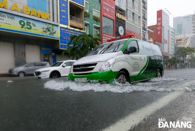 An ambulance was spotted driving through the high water on a flooded section of Nguyen Van Linh Street. Photo: XUAN SON