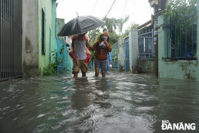 People in residential groups No. 26 and 27 in Thanh Khe Tay Ward, Thanh Khe District moved their children to a safe place because their places of residence were submerged in between 50cm and 1m of floodwater. Photo: XUAN SON