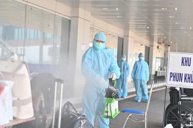 Hành lý xách tay của khách được phun khử khuẩn bằng chất khử trùng chuyên dụng.