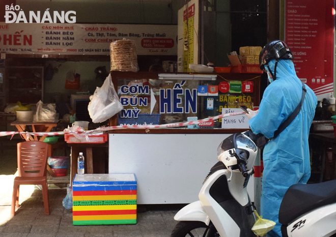 A motorbike delivery man waits to buy food in front of a restaurant on Huynh Thuc Khang Street Photo: HOANG HIEP